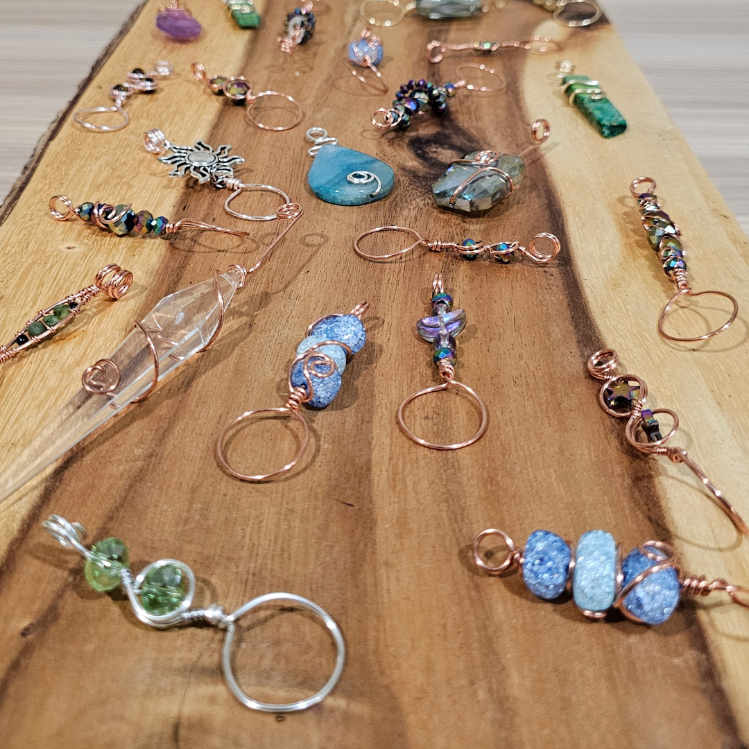 Wooden board displaying Mystery Smoke Wands made with copper wire and varies crystals and glass beads 