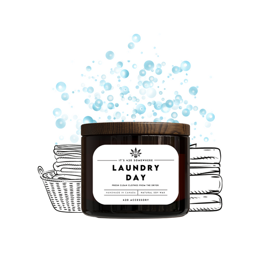 Candle labeled 'Laundry Day' with soap bubbles and a basket of laundry on a white background